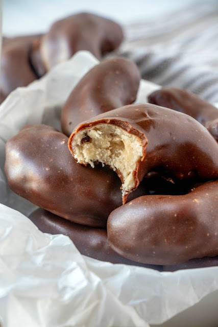 This fudgy frosting is perfect for dipping or spreading over cookies for a chocolaty delicious finish that is stackable. Your cookie trays just got an upgrade! pecan meltaway crescent cookies dipped in fudge icing