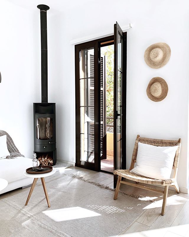 Salón blanco y natural con muebles y objetos de mimbre y de madera clara