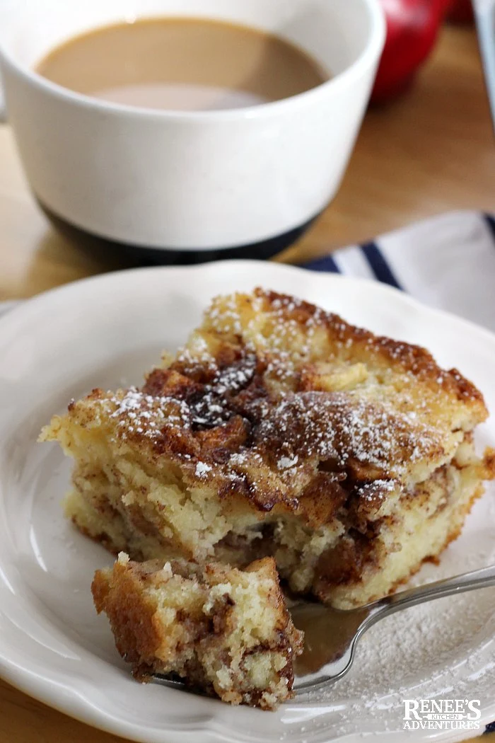 Apple Cinnamon Coffee Cake on plate with fork and a bite with a cup of coffee