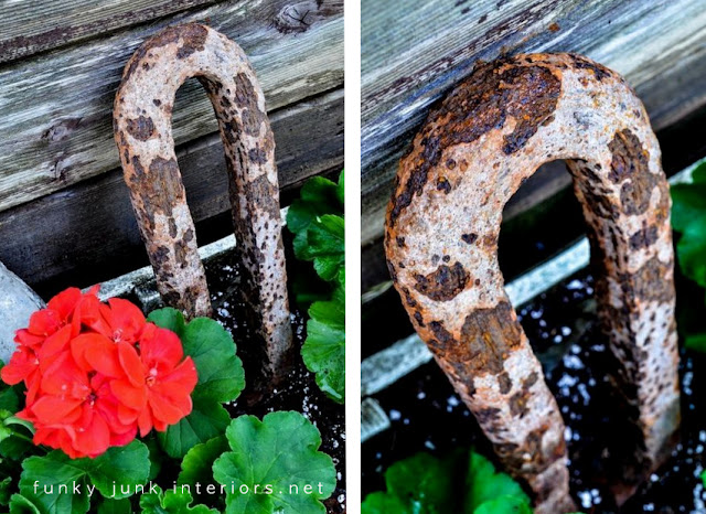 rusty junk as garden art in a flowerbed