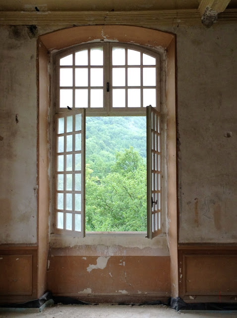 French windows open in a decaying room of Chateau Gudanes