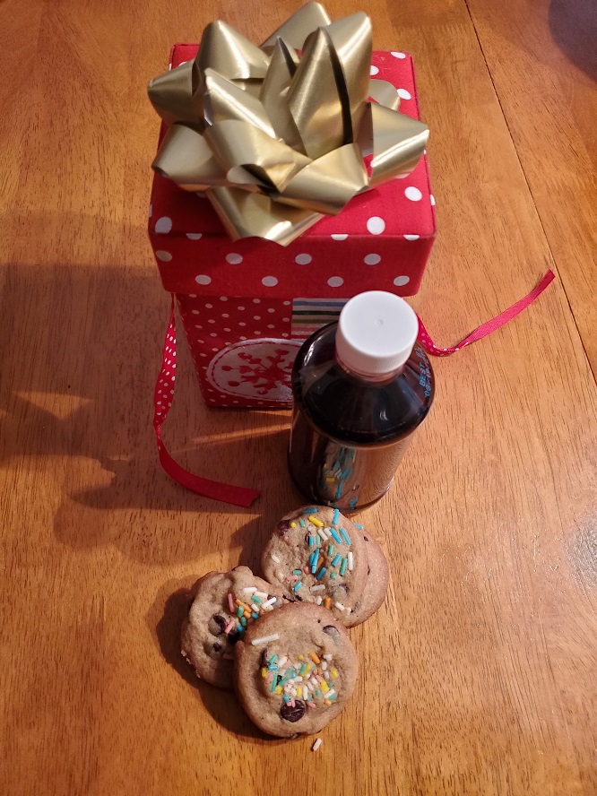 these are the chocolate chip cookies with real vanilla homemade extract in the background that is in a bottle and brown all ready for Christmas gift giving.