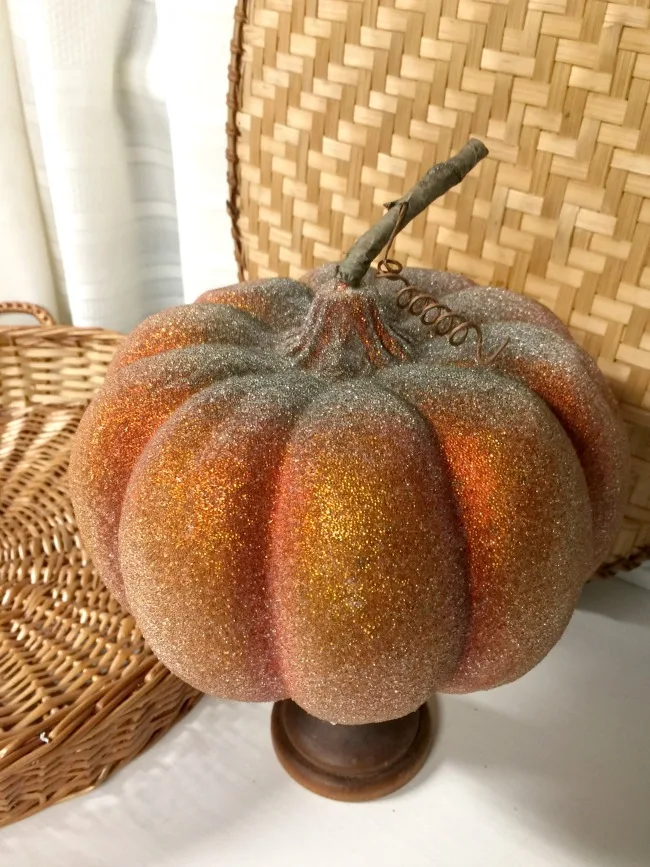 Glittered thrift store pumpkin on wooden stand