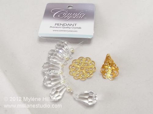 A string of clear crystal briolettes, a round gold filigree and a curved fold filigree