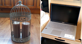 A decorative bird cage with 2 candles in and a new laptop.