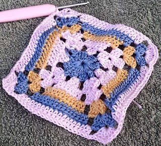 Adrienne's granny square motif is made of 4-ply cotton with a centre round of blue, followed by two rounds of white, one round each of golden yellow and then blue again, finished with a white border.