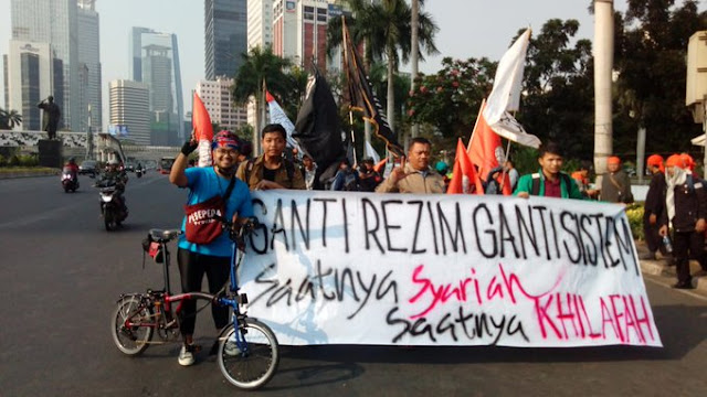 Warta Sunda - Organisasi sayap HTI di kalangan maha siswa, Gema Pembebasan menyuarakan ganti sistem dengan Khilafah pada aksi Mujahid 212 di Jakarta hari ini, Sabtu (28/09/2019). Hal tersebut diketahui dari foto mereka yang diposting akun Twitter #HTIdiHati #KhilafahAjaranIslam @INAMilikAllahYk. Ada bendera Gema Pembebasan dan HTI.