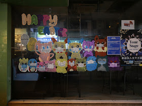 "Happy Easter" along with numerous animals wearing face masks painted on a window 