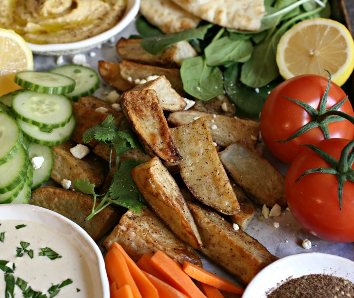 Recipe for a Middle Eastern inspired appetizer platter with za'atar roasted potatoes, hummus and tahini dips.