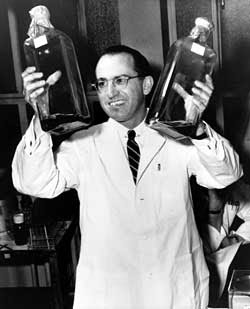 Dr.Jonas Salk with his virus culture bottles