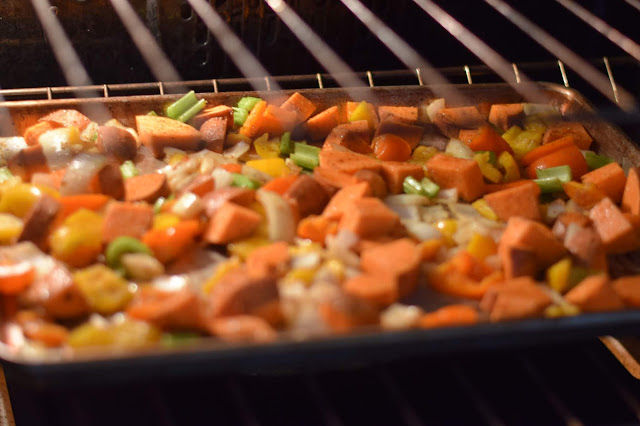 The sweet potatoes, onions, celery, and garlic roasting on a baking sheet in the oven.  