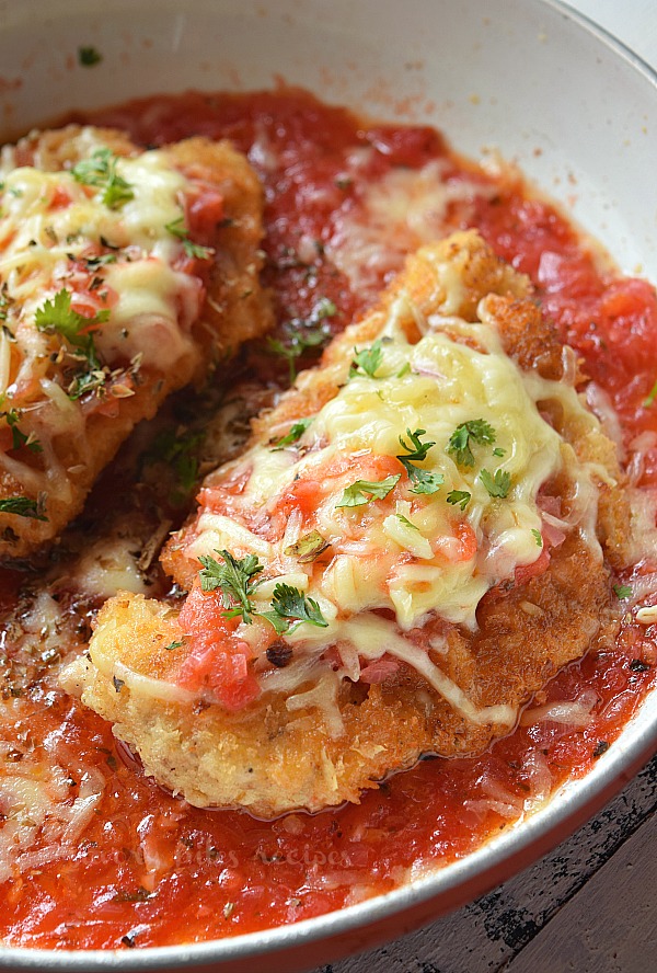 best oven baked chicken parmesan with homemade easy marinara sauce served in a pan topped with mozzarella