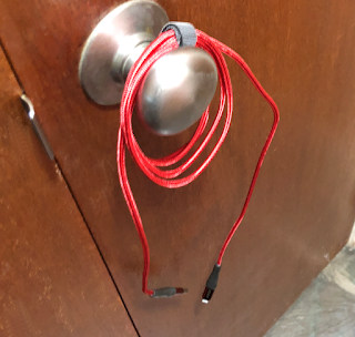 Charging cable with Sugru Moldable Glue reinforced ends hanging from doorknob to dry