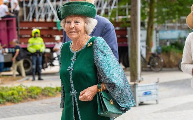 The Princess wore a green embroidered skirt suit, embroidered cape and green hat, gold brooch