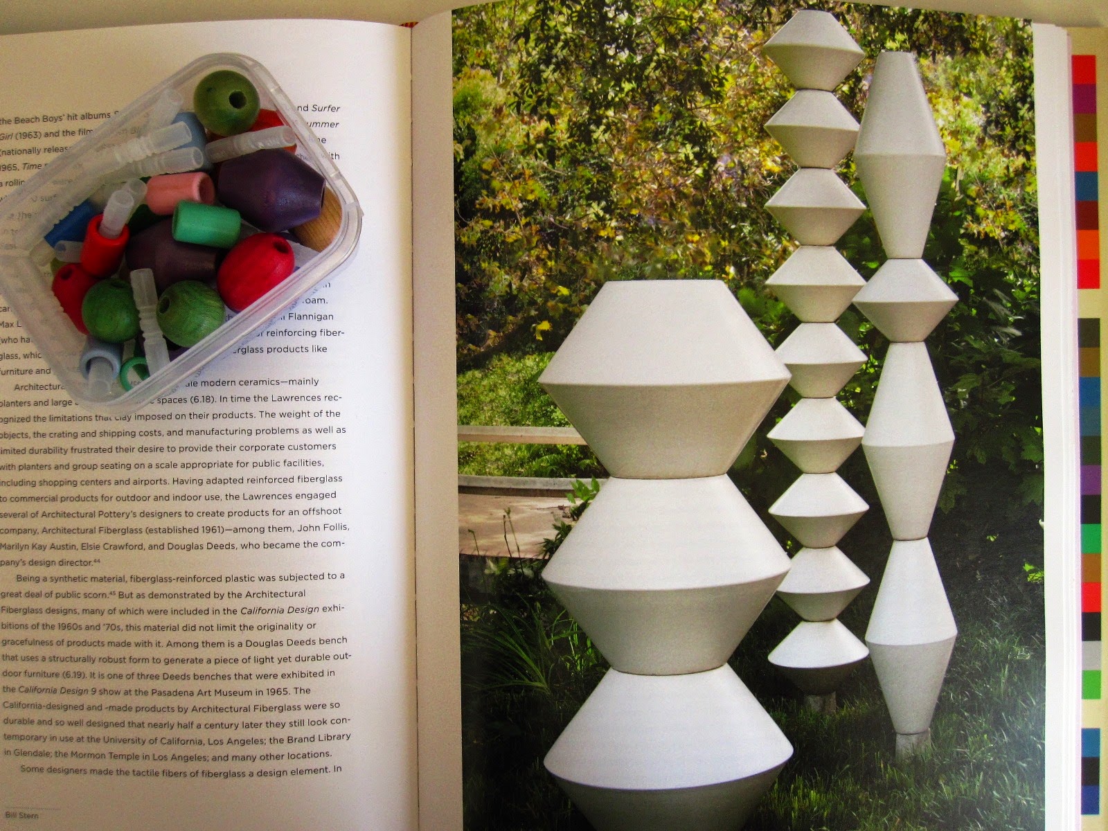 Picture in a book of La Gardo Tackett's garden sculptures, with a container of wooden beads next to it.
