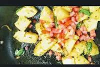 Mixing tomato into potato mixture for Jeera aloo recipe