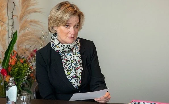 Princess Delphine of Belgium wore a black belted blazer and silk satin print scarf from Saxe-Coburg. Professor Tessa Kerre is president of the fund