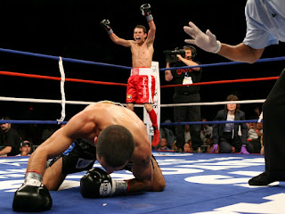 [box tra due uomini, uno cade sul ring mentre l'altro salta perchè vince]