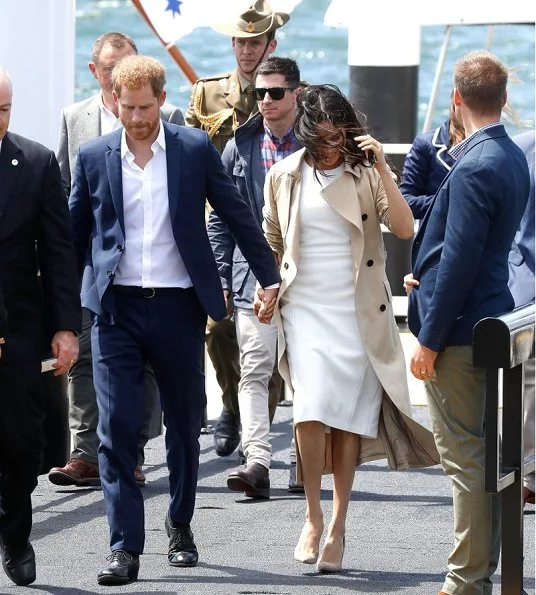 Meghan Markle wore a white Blessed dress by Australian designer Karen Gee, and she wore ​Stuart Weitzman suede pump in Haze Beige