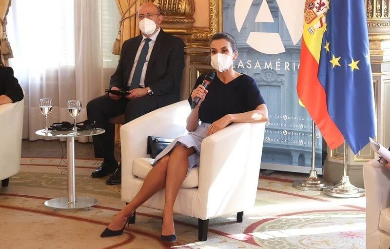 Queen Letizia wore a v-neck pure silk flared sleeves navy blue top and a sky-blue high waisted pencil skirt from Hugo Boss