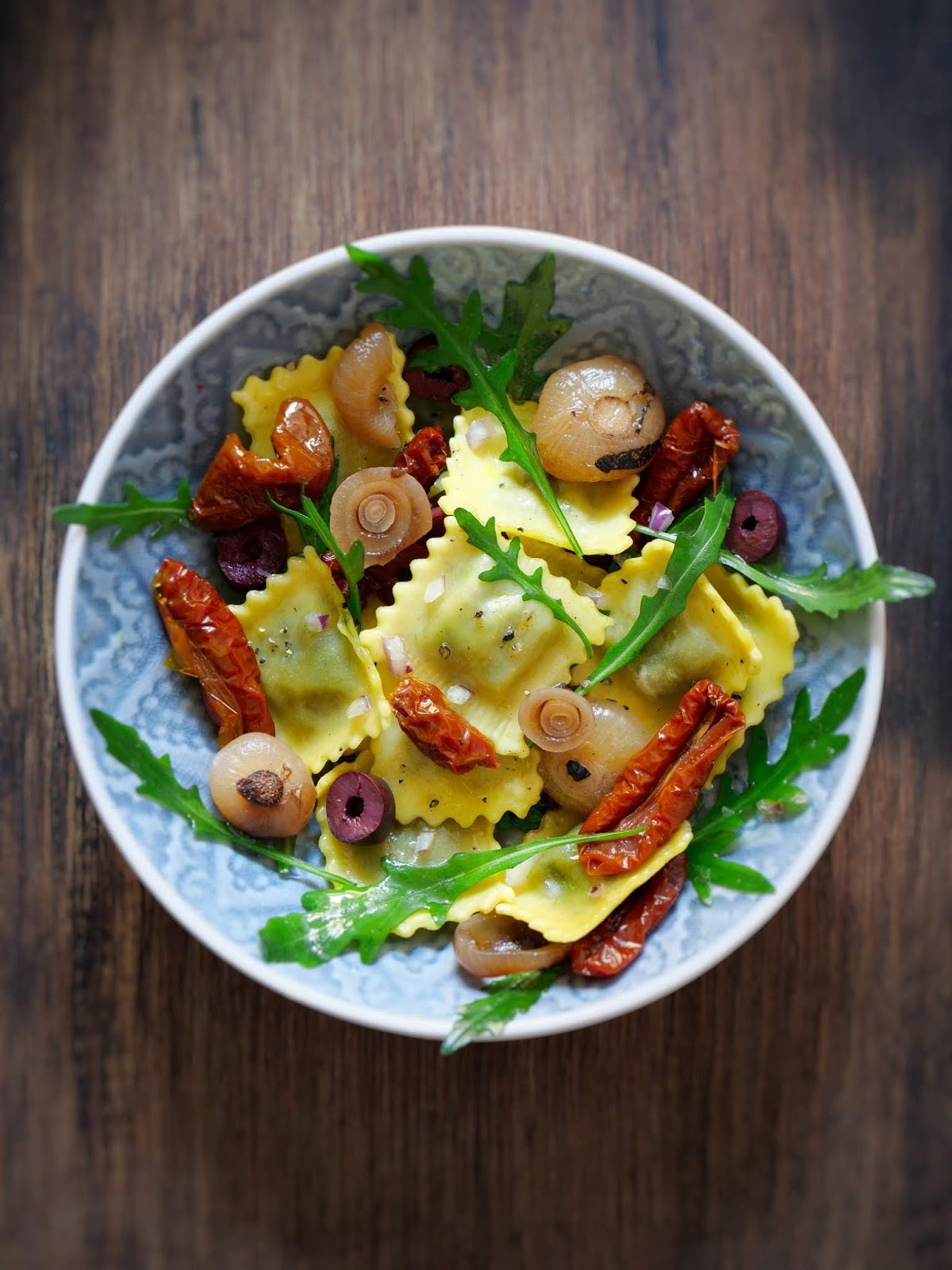 Ravioli-Salat mit Borrettane-Zwiebeln, Rucola, getrockneten Tomaten und ...