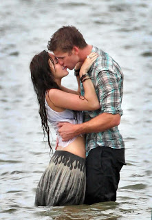 boy kissing a girl passionately standing in water