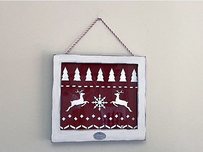 Stenciled sweater pattern sign in a white frame