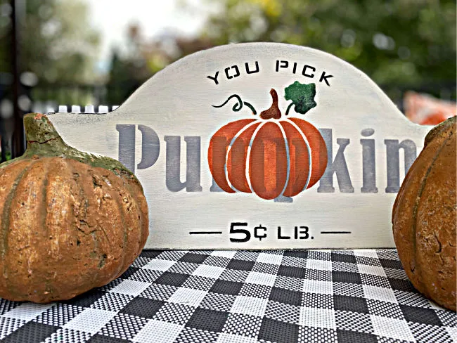 metal pumpkin sign surrounded by pumpkins