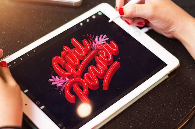 The phrase "Girl Power" in fancy lettering on a tablet.