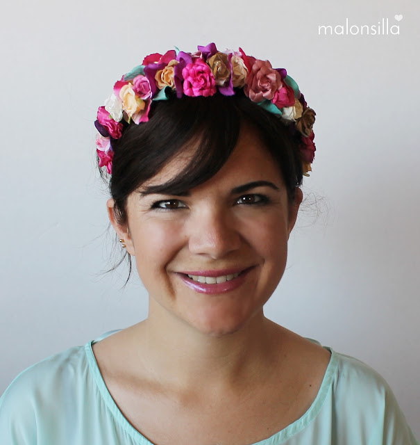 Chica de frente con look de diadema flores en varios colores, predomina el fucsia