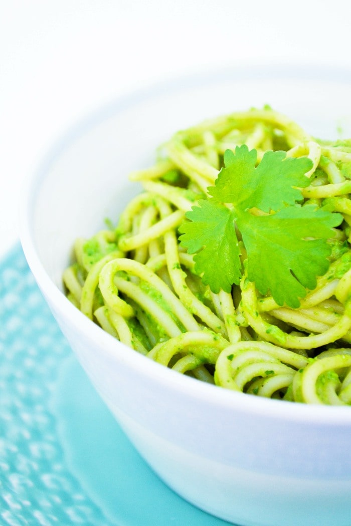 A close up of spaghetti in green sauce