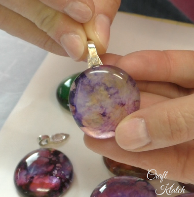 Glass gem with purple and gold ink with a silver bail