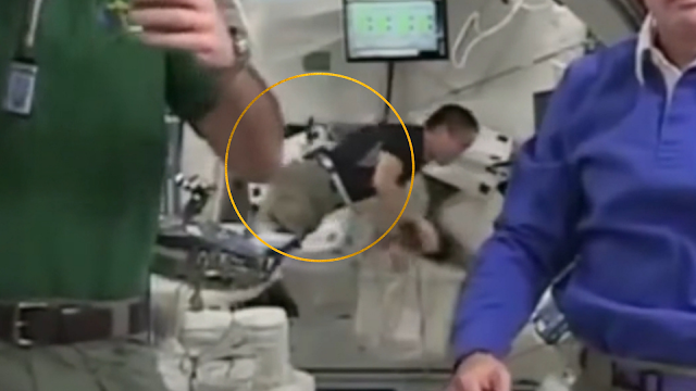 Astronaut wearing a harness in the ISS live feed.