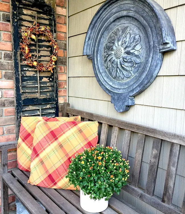 Outdoor bench with shutter, flowers and pillows
