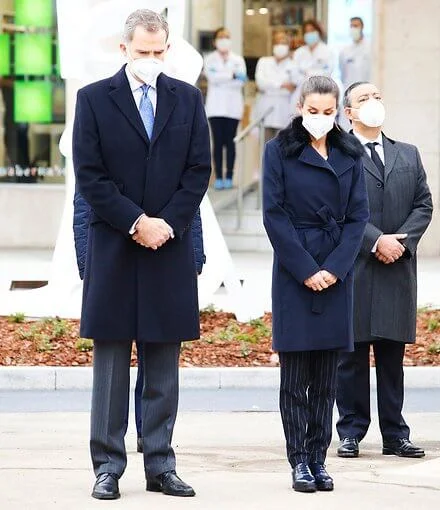 Queen Letizia wore a Canika wool with wrap belt coat from Hugo Boss, and stripe navy trousers and blazer from Boss, and oxford shoes from Uterque