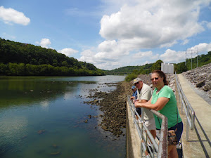 Lisa, George and Tim watching a fisherman reel in a fish.