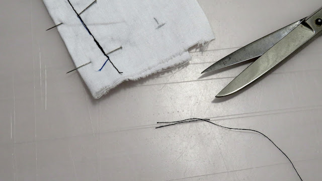 Hilos cortados del inicio de costura de la pinza