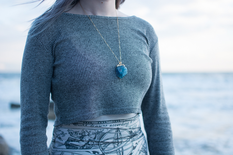 portrait of a girl on the beach long sleeve crop top black milk ancient maps bodycon dress big hipster glasses crystal necklace