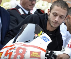 Valentino Rossi pictured at Simoncelli's funeral with one of the two motorcycles placed either side of the coffin