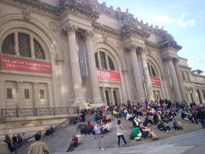the metropolitan museum of art in day with many visitors on the steps