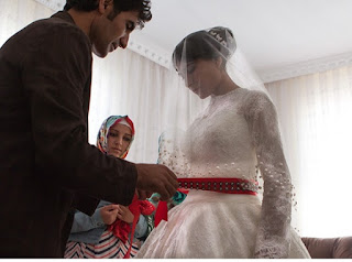 Why do housewives wear red belts with bridal dresses in Turkey?