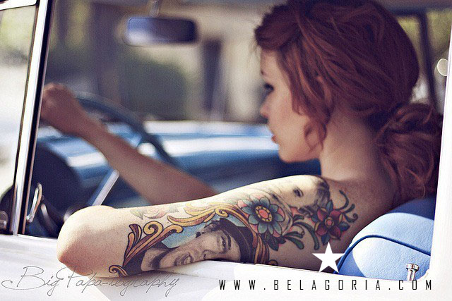 Mujer en su auto lleva tatuajes en el brazo