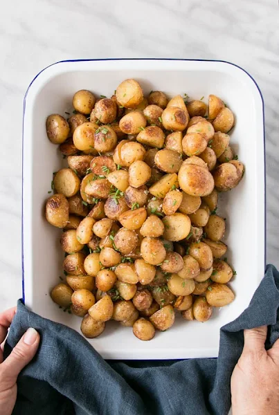 Top view of crispy salt and vinegar potatoes in a white baking dish.