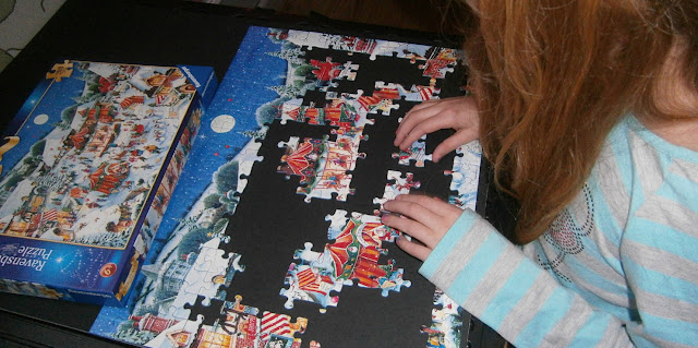 child completing Christmas jigsaw puzzle