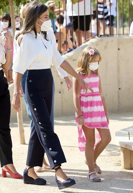 Queen Letizia wore a white shirt by Adolfo Domínguez with buttoned navy Hugo Boss trousers. Castaner espadrille wedges