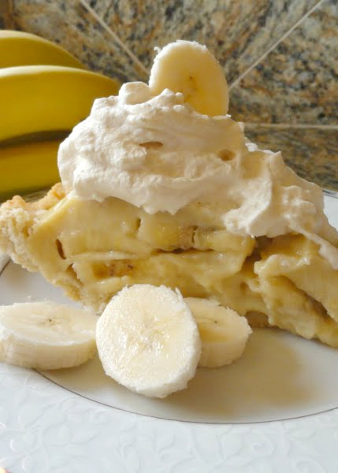 Banana Cream Pie slice with whipped cream and a sliced banana.