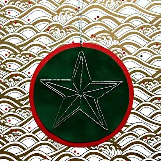 star stitched with silver thread on layers of green velvet paper and red paper as tree ornament
