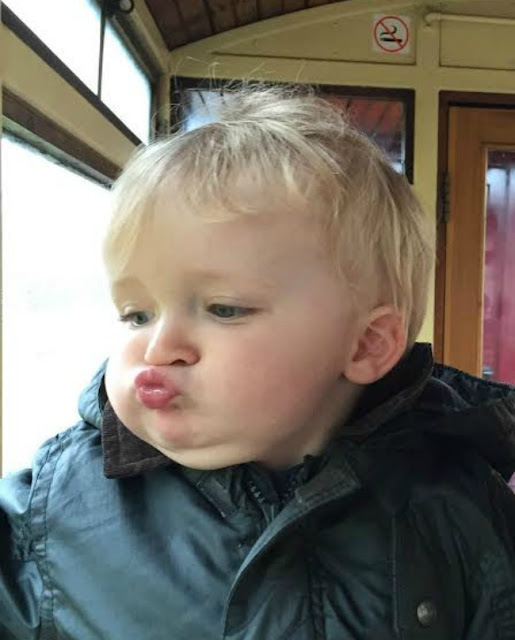 baby with lips puckered inside carriage