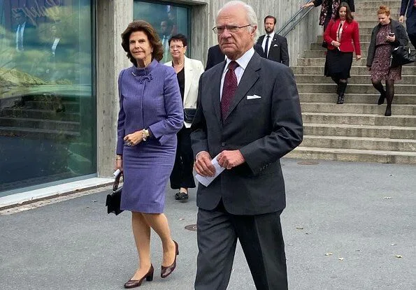 Queen Silvia wore and blue jacket and skirt, skirt suit. She is wearing gold earrings and gold bracelet