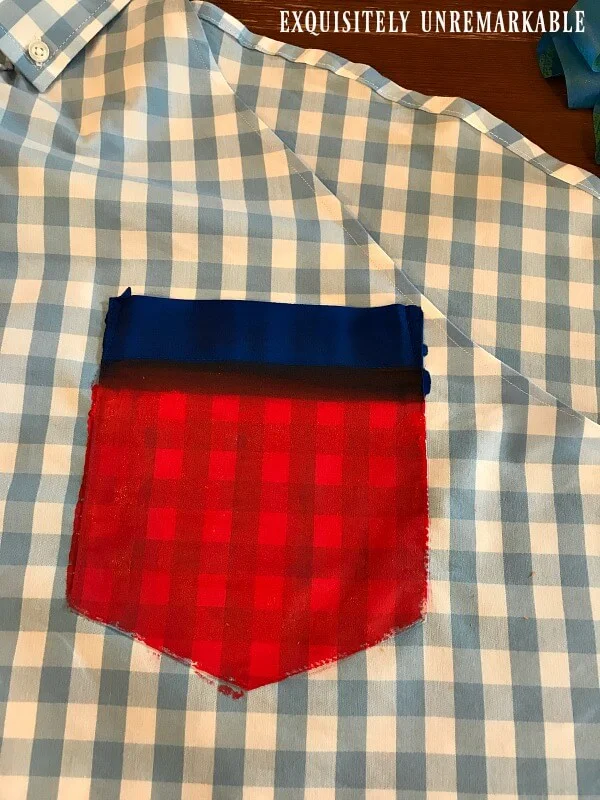 Red fabric paint on pocket of men's shirt with blue stripe